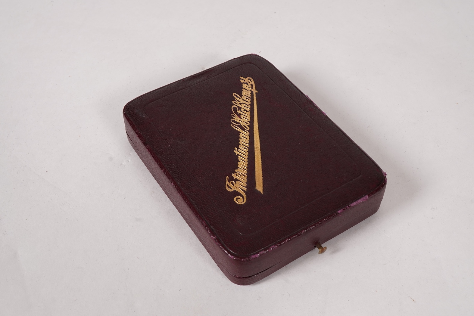 An early 20th century International Watch Company engine turned 14k yellow metal open faced keyless lever pocket watch, together with a Viennese? two colour yellow metal albert, maker's mark, LE